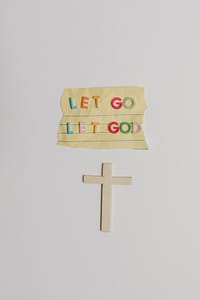 A paper written let Go let God
And a cross cut out of paper
