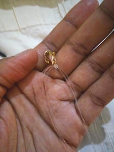 A hand holding black beads 